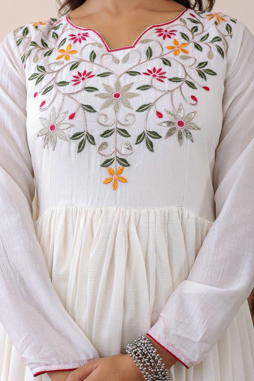 White embroidered dress with colorful floral patterns