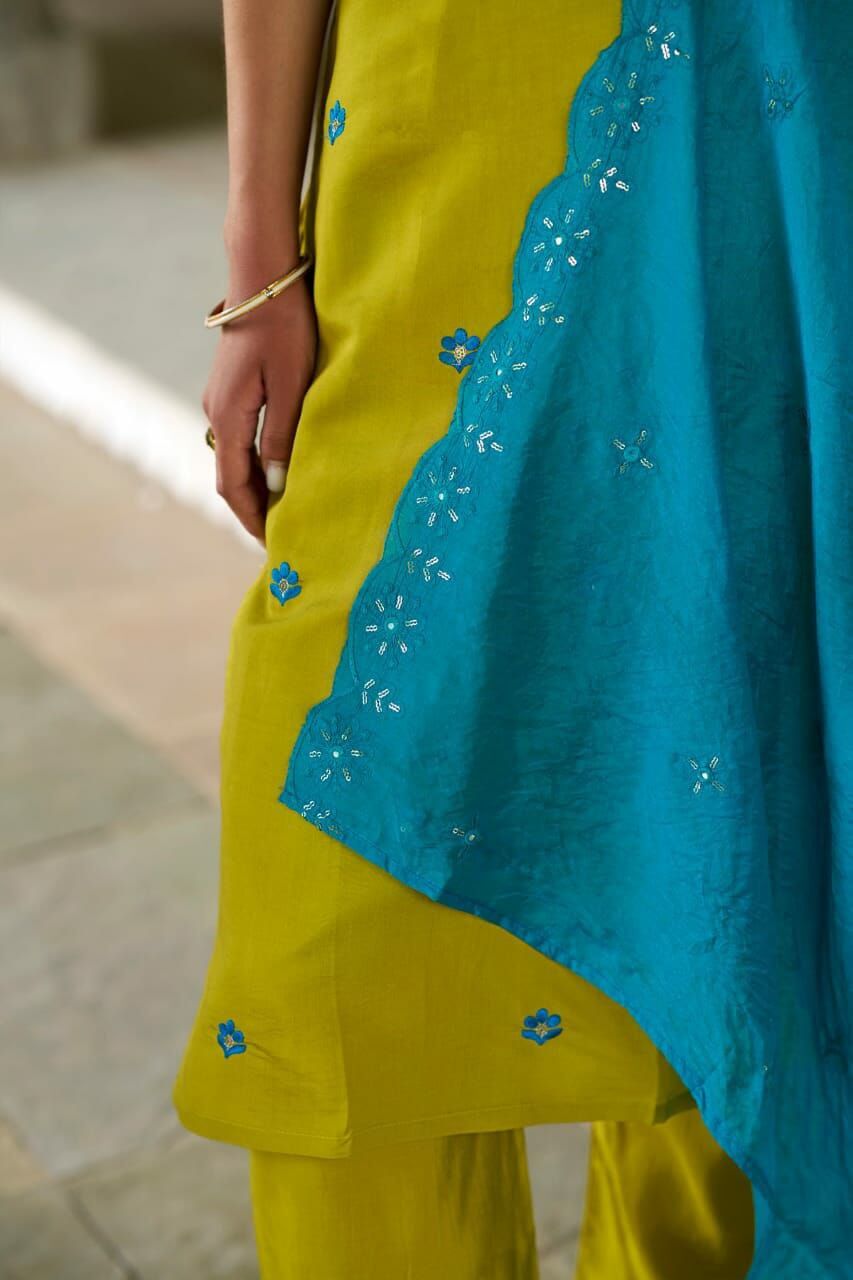 Close-up of a woman's kurti set featuring a yellow kurti and a turquoise embroidered dupatta.