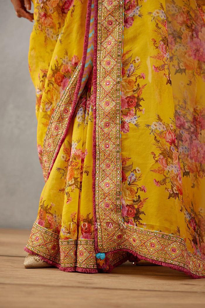 Trendy yellow georgette saree for women with floral print and embroidered lace border.